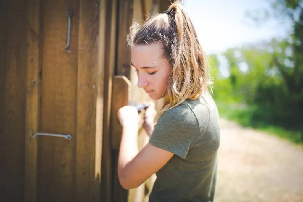 Block Island FarmHer Bailey Payne opens the door to a chicken coop
