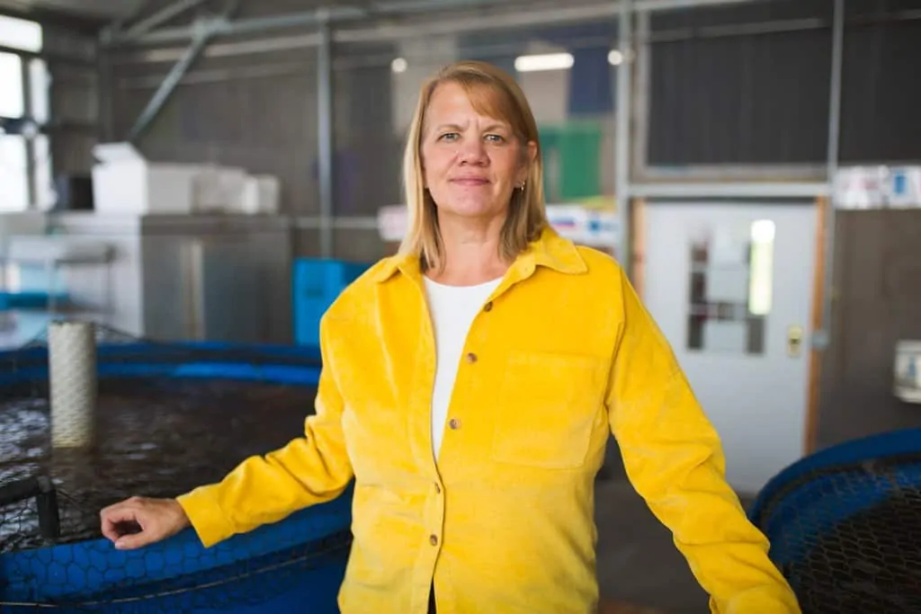 Rebecca Nelson stands in front of tilapia fish tanks at Nelson and Pade in Montello, Wisconsin