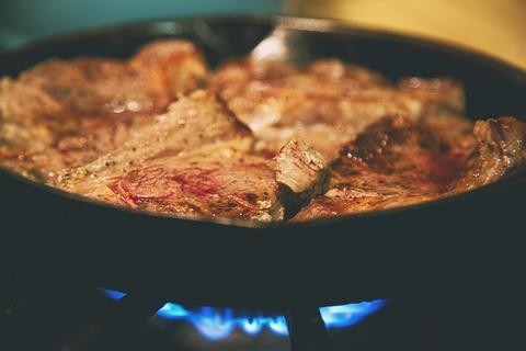 Meredith cooks a steak in their family's cast-iron skillet.