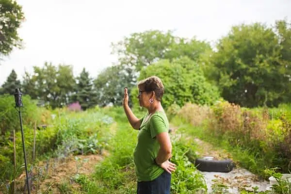 FarmHer Lisa Kivrist stands in a garden