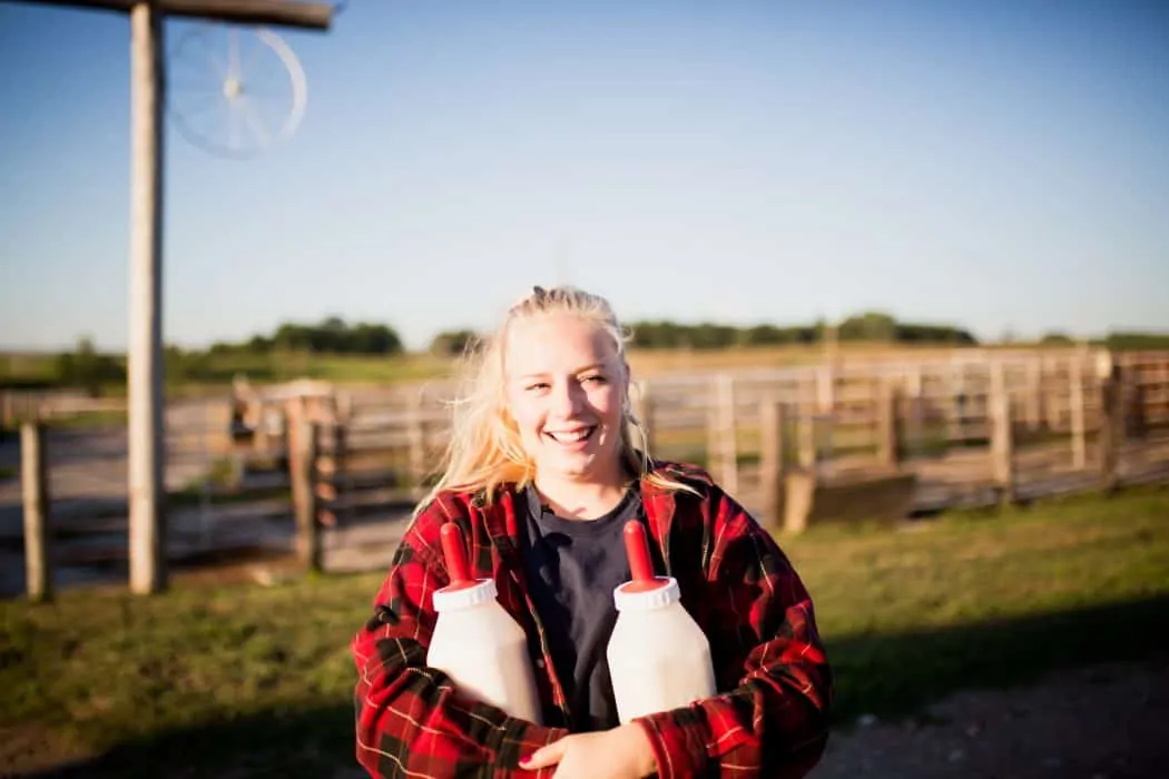 FarmHer Hannah Borg hold bottles for calves on her family farm