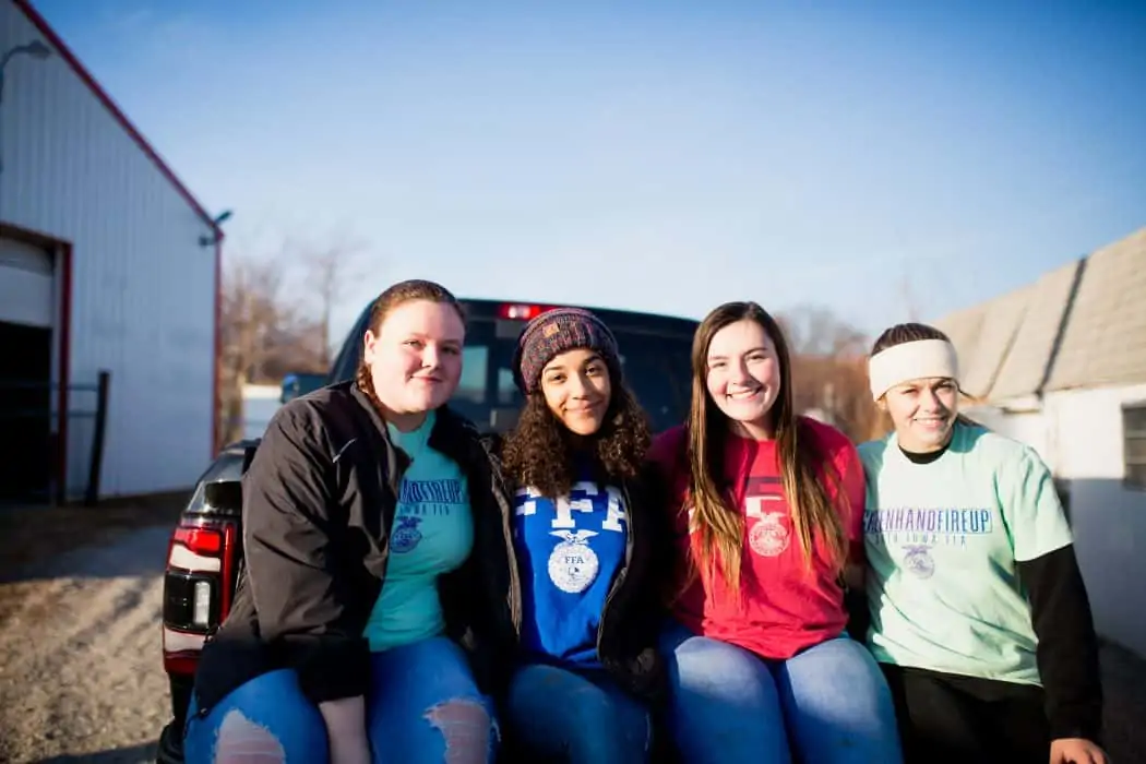 FFA members sitting on the back of a Ram pickup truck on a winter day. 
