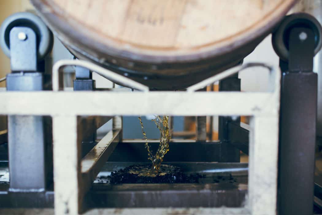 A barrel of bourbon spilling bourbon out. 