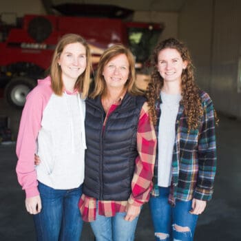 Jolene Palmer and her daughters standing in a shop on their farm.
