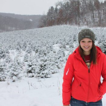 Sarah Scharlau standing at her Christmas tree farm