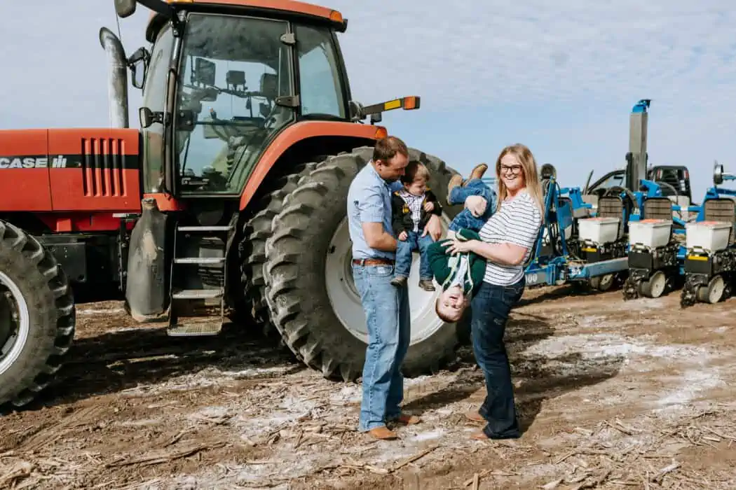 Melissa Nelson of Hungry Canyon greeting cards and her family on the farm next to a tractor.