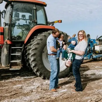 Melissa Nelson of Hungry Canyon greeting cards and her family on the farm next to a tractor.