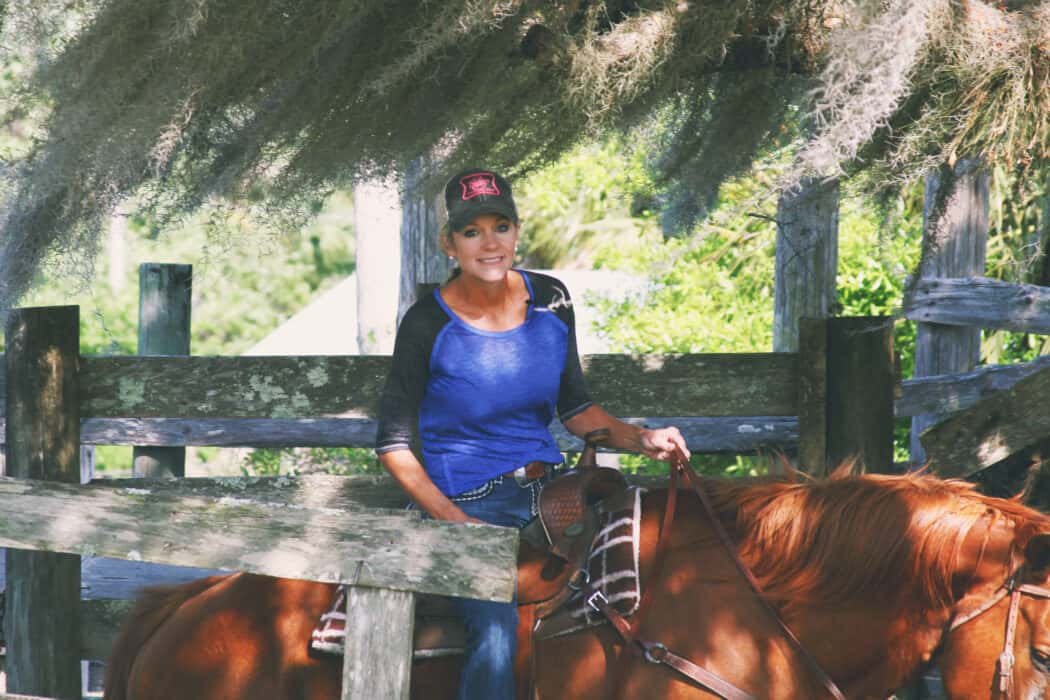 A woman riding a red horse on her family ranch