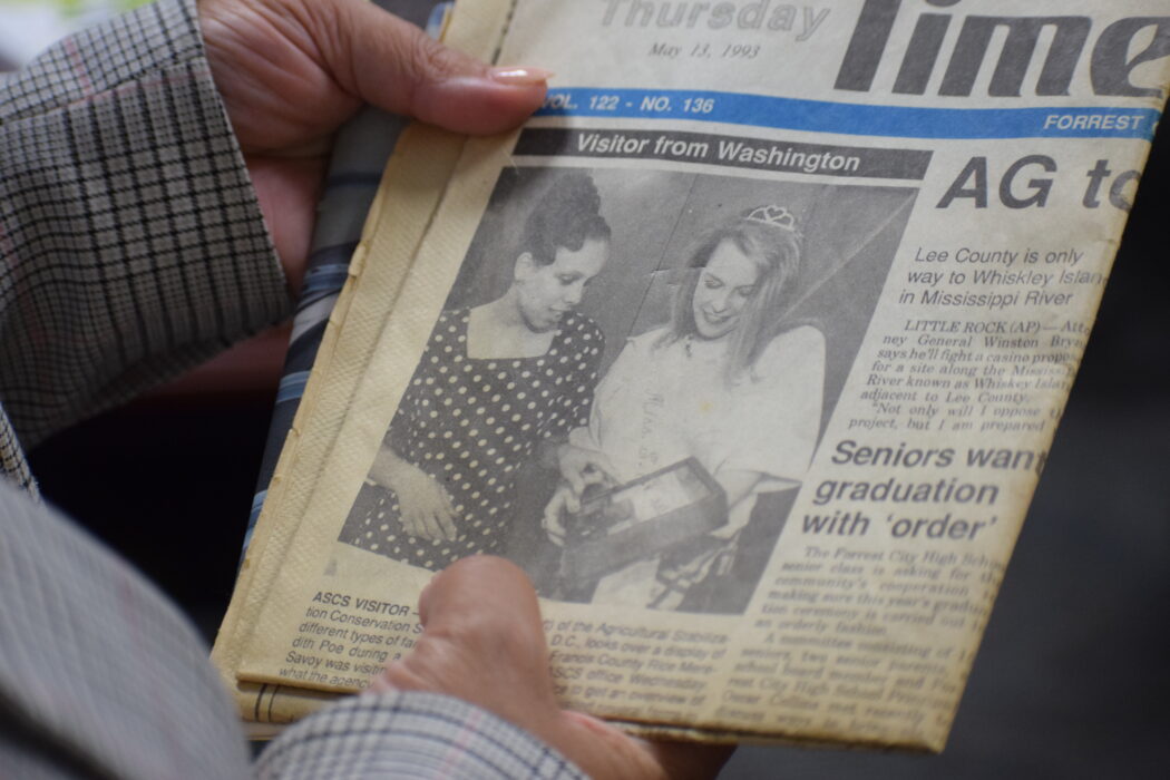 Kimberly Graham featured in the Forest City, Arkansas Times Herald as the ‘Visitor from Washington,’ with a photo standing with Miss St. Francis Country Rice on the paper's front page