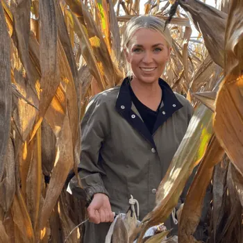 FarmHer host Kirbe Schnoor in a field of corn filming on location for FarmHer Season 6.