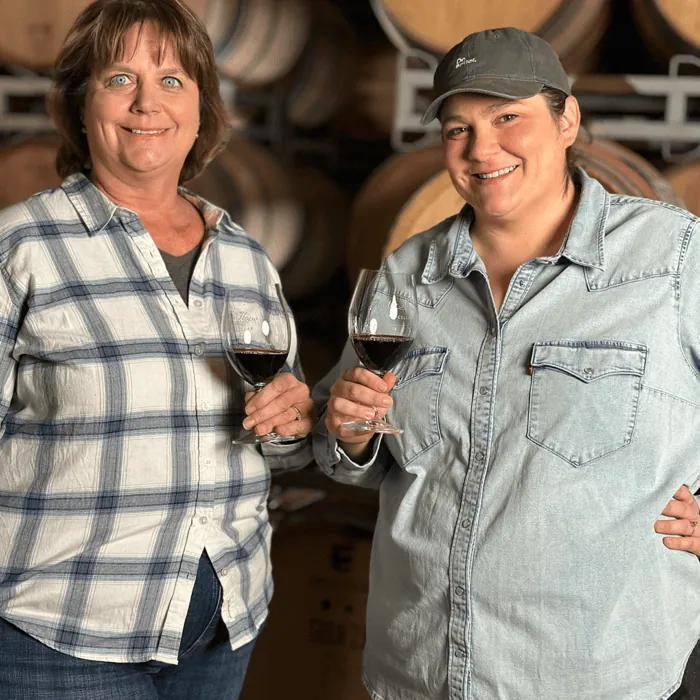 Hope Family Wines Vineyard Director Stasi Seay, left, and Assistant Winemaker Samantha Taylor holding two glasses of red wine.