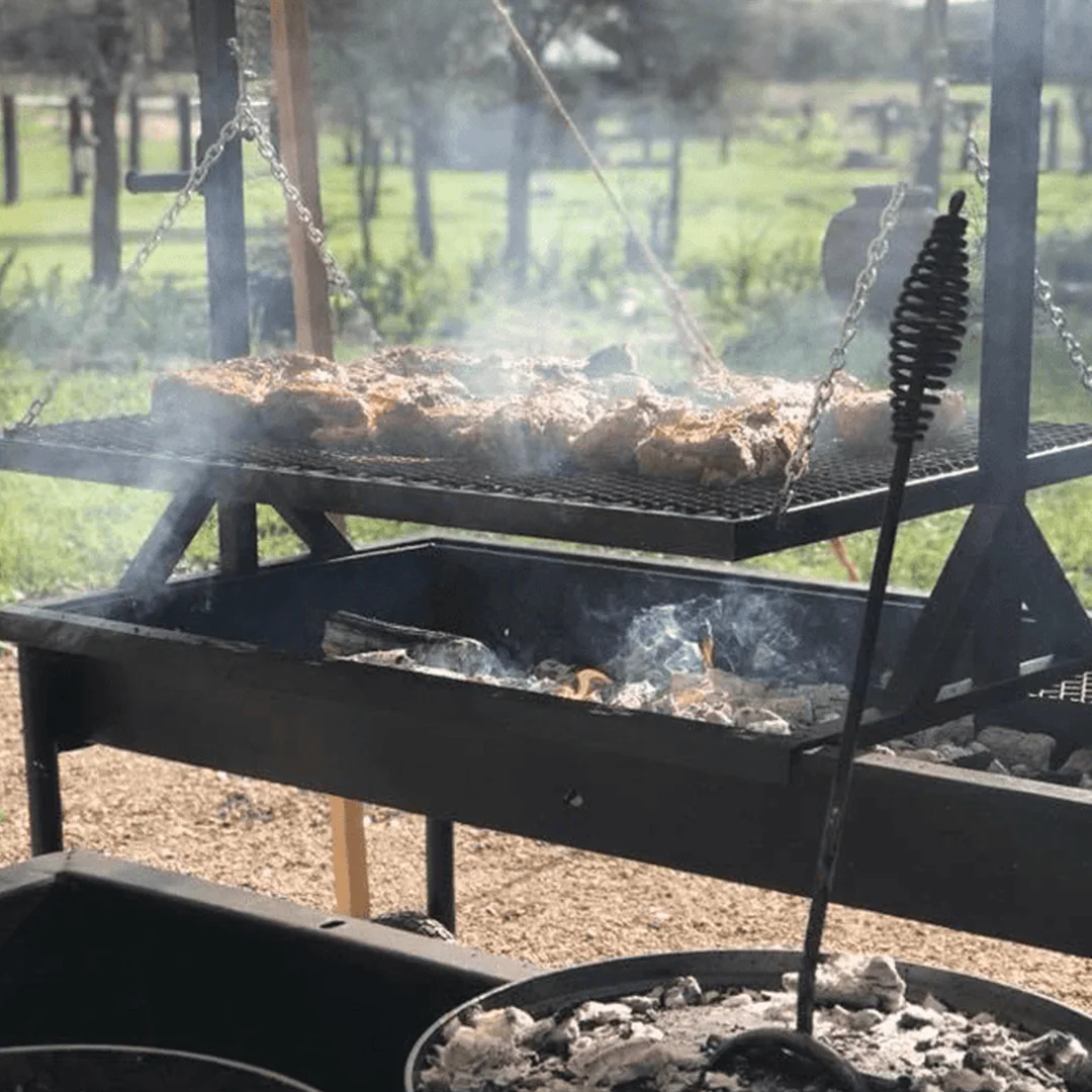 A homemade Santa Maria-style grill made with found objects