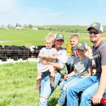 Beef FarmHER Moriah Hunter (Season 6) smiling with her family in front of their herd of beef cattle on a sunny day.